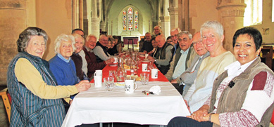 Charity Soup Lunch organisers and attendees sat at tables in the church enjoying lunch